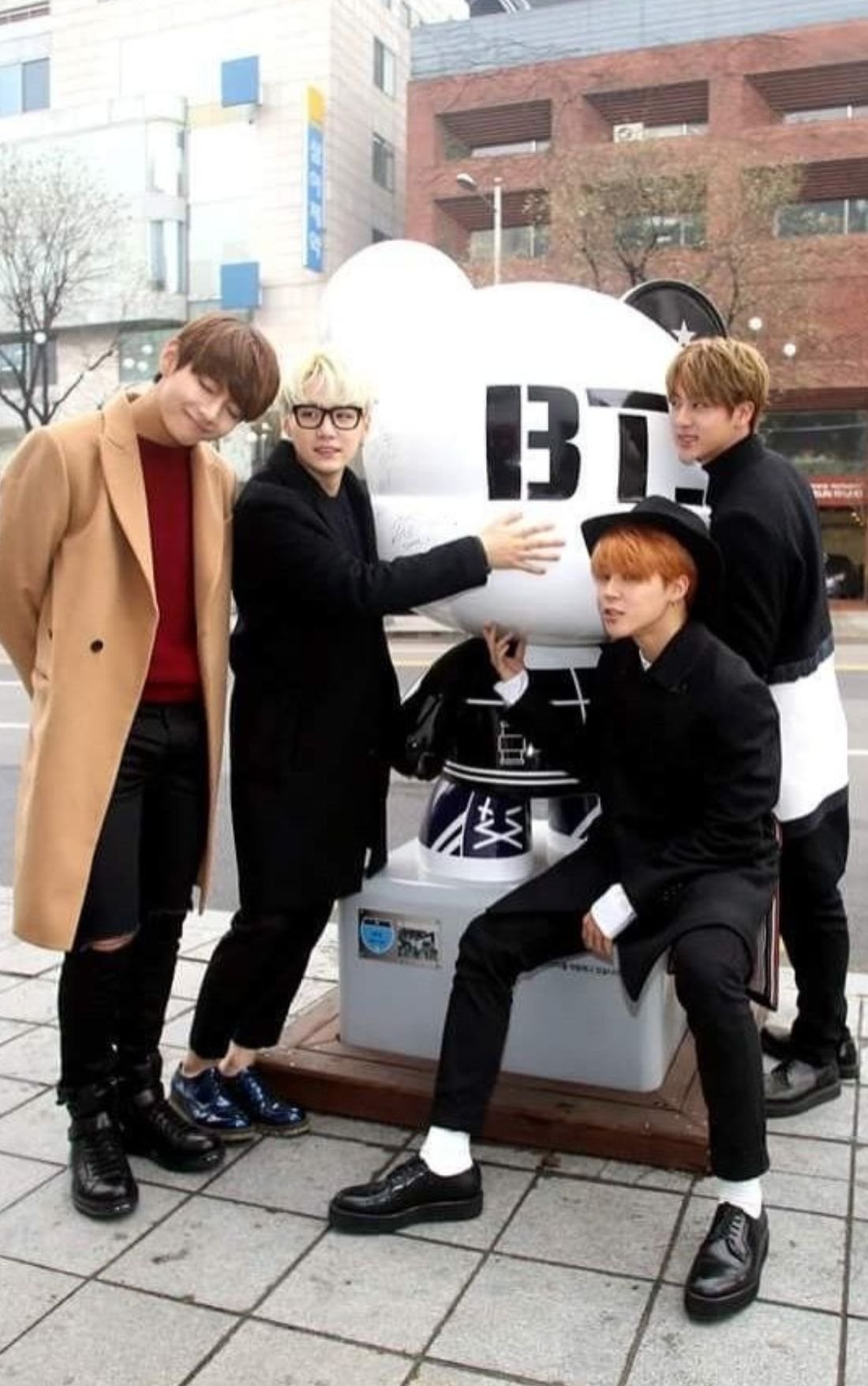 Integrantes do BTS em frente à estátua temática em Seul