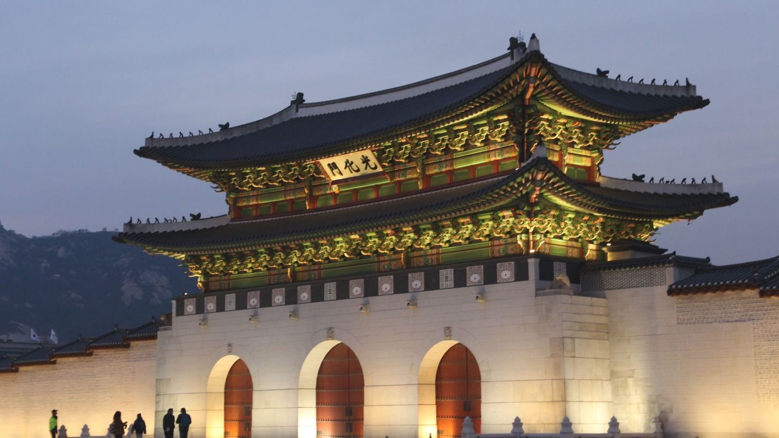 Portão Gwanghwamun iluminado ao anoitecer, em Seul